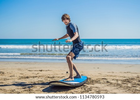 Stock photo: Young Man Surfer Training Before Go To Lineup On A Sand Beach Learning To Surf Vacation Concept S