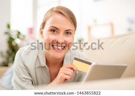 Stock photo: Young Online Shopper With Plastic Card And Touchpad Making Order On Couch