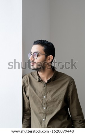 Foto d'archivio: Serious Or Serene Guy In Eyeglasses Looking Through Office Window At Break