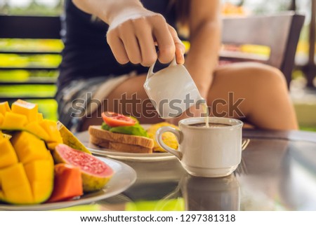 Foto stock: The Moment Pouring Milk Into Coffee Woman Pouring Cream In Coffee