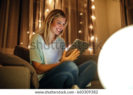 Zdjęcia stock: Smiling Young Woman Using Tablet Computer At Home At Night Befor