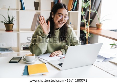 ストックフォト: Beautiful Young Girl Sitting In Headphones And With Microphone At Table In Office And Talking