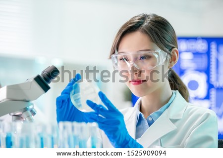 Foto stock: Medical Research Asian Scientist Working With Microscope Doing R