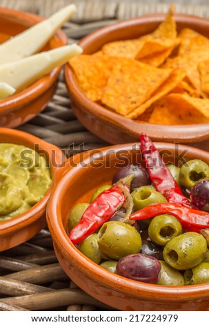 Foto d'archivio: Tapas Marinated Olives Tortilla Chips Guacamole Manchego