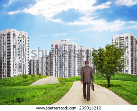 Businessman Walking Along Road Running Through Green Hills Towards City Stockfoto © cherezoff