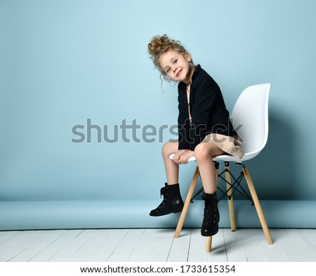 Stok fotoğraf: A Teenage Girl In White Clothes Is Sitting On A Chair On A Yellow Background
