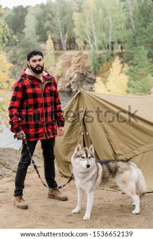 ストックフォト: Young Hiker In Casualwear Holding Cute Husky Dog By Leash While Standing By Tent