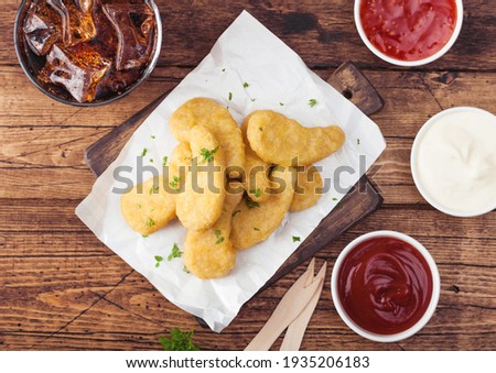 Foto stock: Buttered Chicken Nuggets On Chopping Board With Glass Of Cola And Ketchup On Wooden Background Top