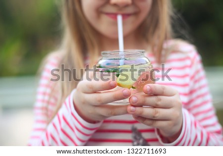 ストックフォト: Little Girl In Striped Blouse With Ginger Lemonade Sitting Outdo