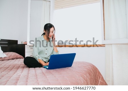 Foto stock: Young Woman Is Working On A Laptop In His Bed On A Background Of A Panoramic Window Overlooking The