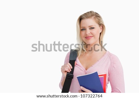 Foto d'archivio: Peaceful Blonde Woman Holding Notebooks Against A White Background
