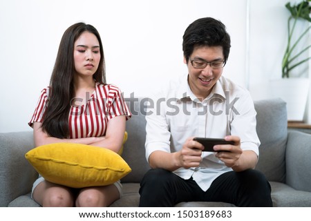 Stockfoto: Bored Woman With Boyfriend Using Smartphone