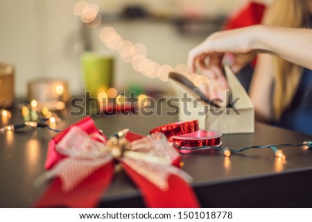 Stock fotó: Young Woman Is Packing Presents Present Wrapped In Craft Paper With A Red And Gold Ribbon For Chris