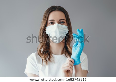 ストックフォト: Female Doctor Or Nurse Wearing Surgical Gloves Putting On Medica