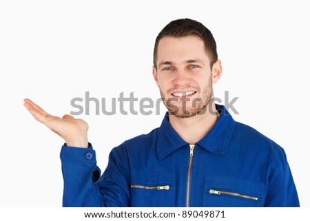 Stock foto: Young Mechanic Presenting Something On His Palm Against A White Background