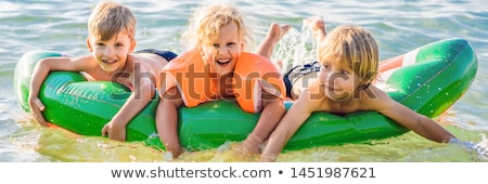 Zdjęcia stock: Children Swim In The Sea On An Inflatable Mattress And Have Fun Banner Long Format