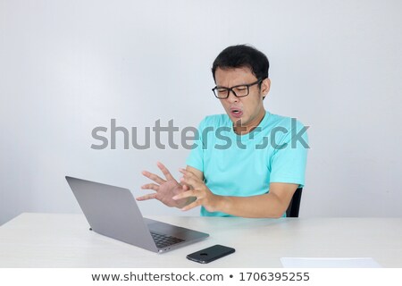 ストックフォト: Young Asian Man Is Angry And Shock With Laptop Indonesian Man Wearing Blue Shirt