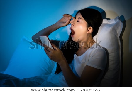 Zdjęcia stock: Tired Woman Yawning Sitting On Her Bed