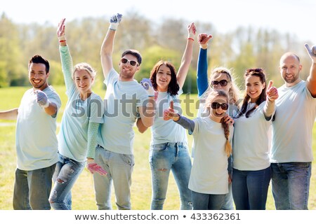 Foto d'archivio: Group Of Volunteers Showing Thumbs Up In Park