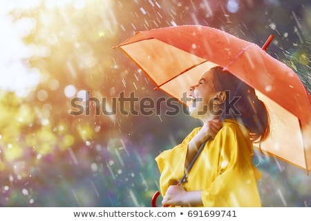 Foto stock: Cheerful Young Girl Wearing Raincoat