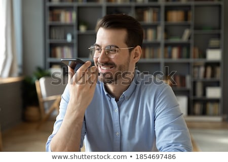 Foto stock: Businessman Records Voice By Smartphone At Office