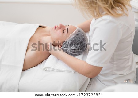 Foto stock: Masseur Massaging Face Of A Beautiful Young Woman Lying On The