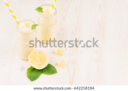 Stockfoto: Yellow Lemon Smoothie In Glass Jars With Straw Mint Leaf Honey Top View White Wooden Board Backg