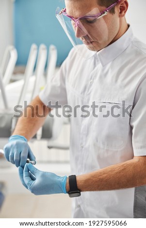 [[stock_photo]]: Crop Dentist Putting On White Gloves