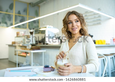 Stock photo: Cute Smiling Female In Casualawear Having Cappuccino And Tasty Bluberry Cake