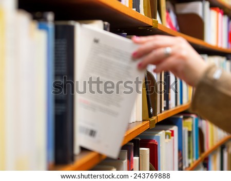 Stock fotó: Woman Choosing A Book From The Shelf In A Library