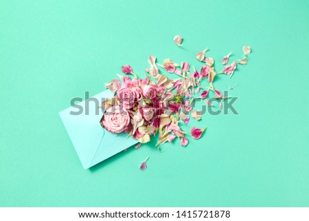 Foto d'archivio: Fresh Pink Roses In Handmade Envelope On A Turquoise Background