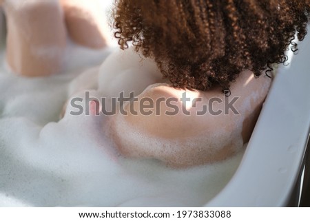 Imagine de stoc: Beautiful African American Woman Bathing In A Tub Full Of Foam
