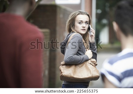 Foto stock: Teenage Girl Using Phone As She Feels Intimidated On Walk Home