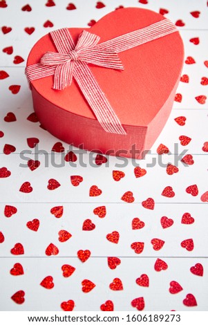 Stok fotoğraf: Boxed Gift Placed On Heart Shaped Red Sequins On White Wooden Table