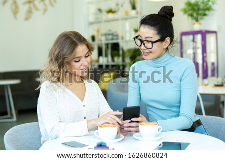 Stock foto: Two Young Friendly Females In Casualwear Discussing Goods From Online Shop
