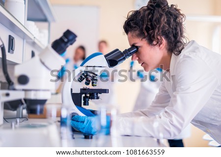 [[stock_photo]]: Young Asian Scientist Working Looking Through A Microscope Doin