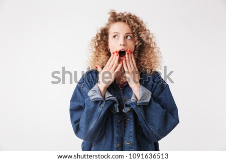 Foto stock: Shocked Blonde Curly Woman In Denim Clothes Covering Her Mouth