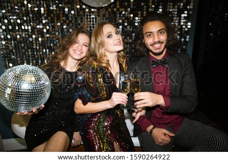 ストックフォト: Group Of Young Cheerful Friends In Festive Attire Making Toast At Party