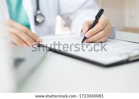 Foto d'archivio: Doctor Writes Notes On The Clipboard Medical Diagnosis Concept