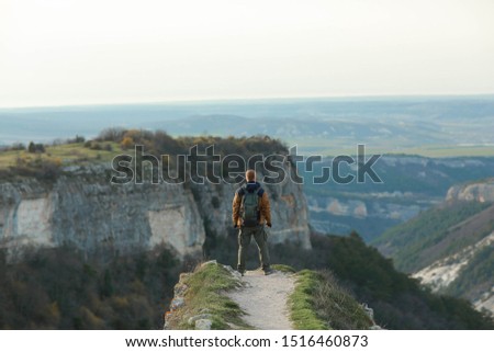 Stockfoto: Young Caucasian Man With Backpack Standing On The Top Of Hill