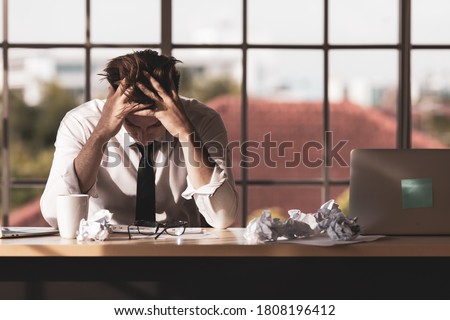 Foto d'archivio: Upset And Worried Young Businessman Sitting And Working At Lapto