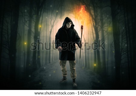 [[stock_photo]]: Man Coming From Dark Forest With Burning Flambeau In His Hand Concept