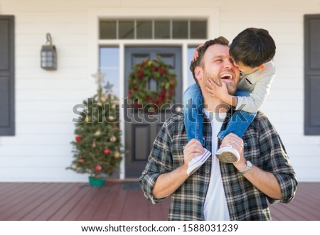 Foto d'archivio: Young Mixed Family On Front Porch Of House With Christmas Decora