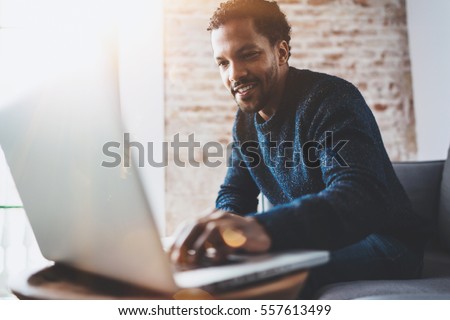 Stock foto: Image Of Focused Young Man Using Laptop While Sitting On Sofa