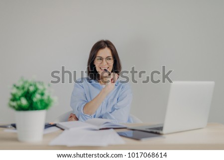 Zdjęcia stock: Intelligent Gorgeous Female Dressed Casually Works At Home Sits In Front Of Opened Laptop Has Happ