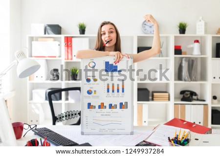 Foto d'archivio: A Young Girl Stands Near A Table And Holds A Marker And A Telephone In Her Hands On The Table Is A