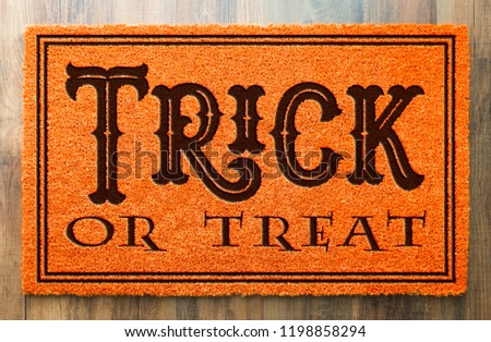 Stok fotoğraf: Trick Or Treat Halloween Orange Welcome Mat On Wood Floor Backgr