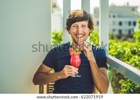 ストックフォト: Man Is Holding Healthy Watermelon Smoothie With Mint And Striped Straws On A Wood Background