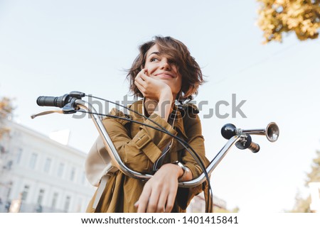 Stock photo: Cute Young Woman Walking In Park With Bicycle Listening Music With Earphones