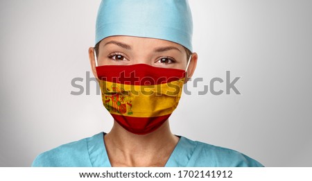 Сток-фото: Covid 19 Pandemic In Spain Asian Doctor With Spanish Flag Print On Surgical Mask Happy Confident Wo